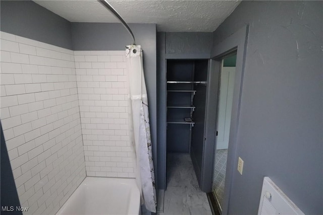 bathroom with shower / bathtub combination with curtain and a textured ceiling