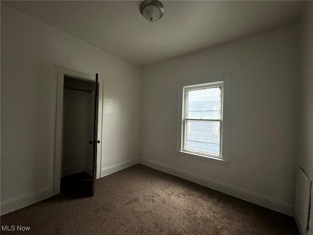 empty room with dark colored carpet