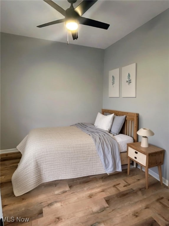 bedroom with ceiling fan and hardwood / wood-style flooring