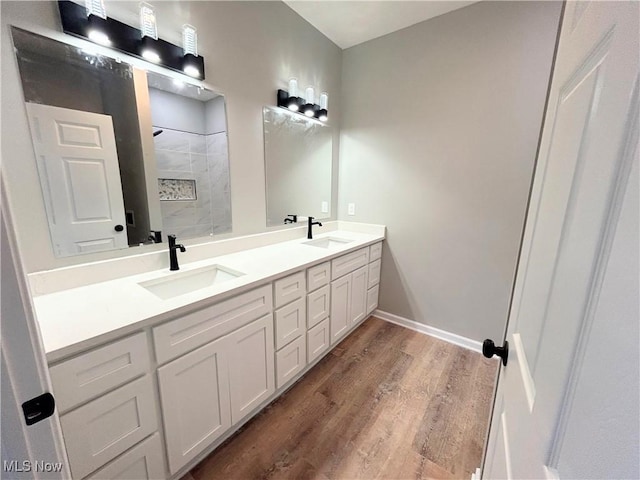 bathroom featuring hardwood / wood-style flooring, vanity, and walk in shower