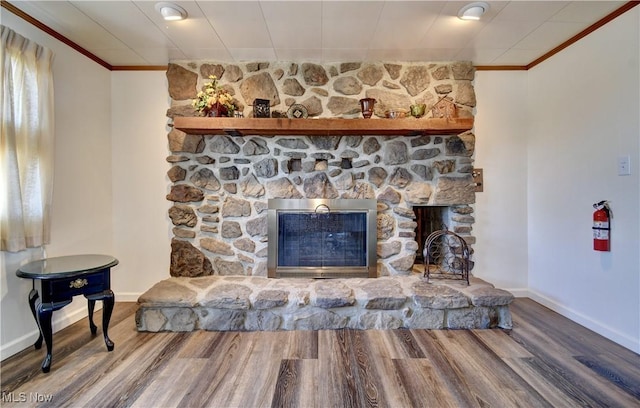 room details featuring crown molding, a fireplace, and wood-type flooring