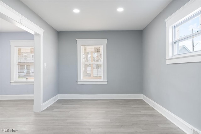 empty room with a healthy amount of sunlight and light hardwood / wood-style flooring