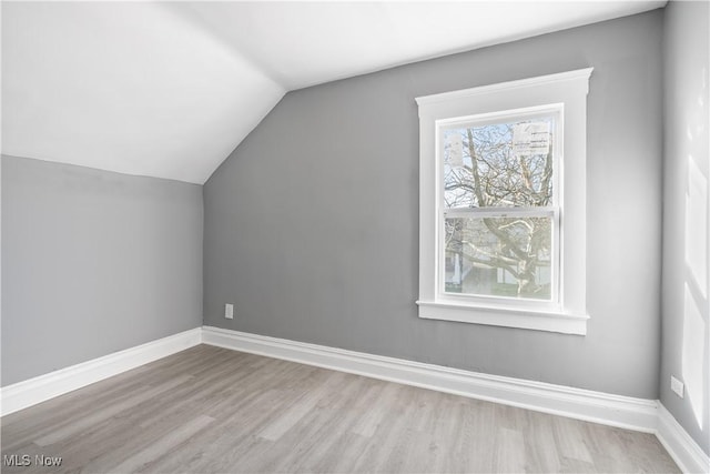 bonus room with light hardwood / wood-style floors and vaulted ceiling