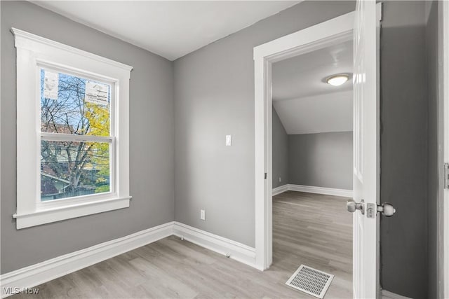 unfurnished room with light hardwood / wood-style floors and lofted ceiling