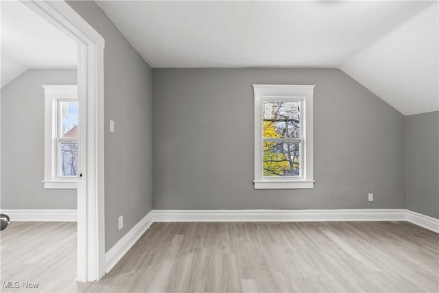 additional living space featuring lofted ceiling and light hardwood / wood-style flooring