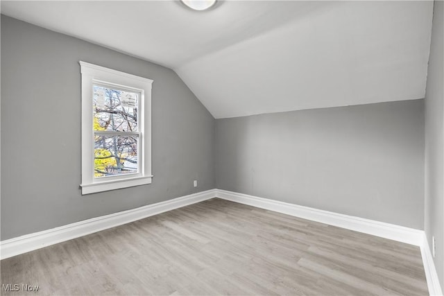 bonus room with lofted ceiling and light wood-type flooring