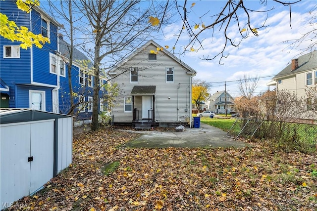 back of house featuring a patio and a shed