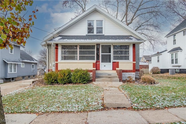 bungalow-style home featuring a front yard and central AC