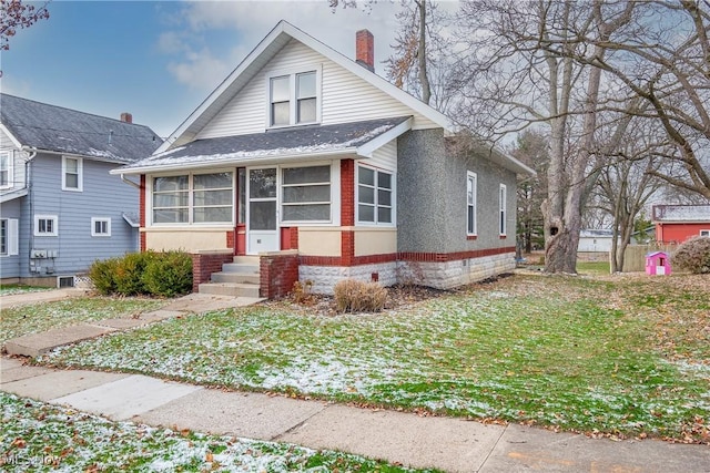 bungalow featuring a front yard and a sunroom