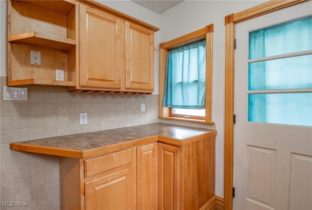 kitchen with light brown cabinetry and tasteful backsplash