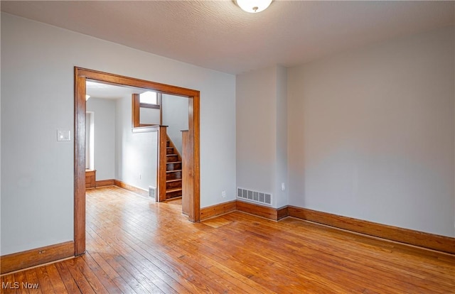 spare room featuring a textured ceiling and light wood-type flooring