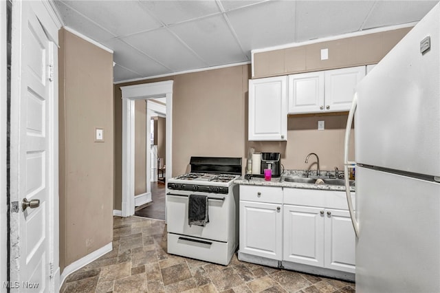 kitchen with a paneled ceiling, white cabinetry, sink, and white appliances