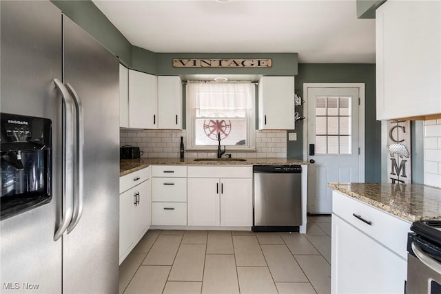 kitchen with a healthy amount of sunlight, white cabinetry, sink, and appliances with stainless steel finishes