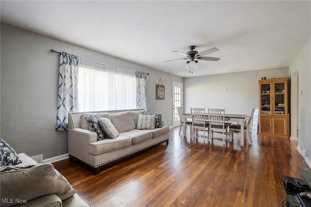 living room featuring ceiling fan and dark hardwood / wood-style floors