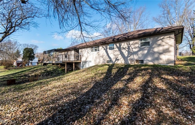 rear view of property featuring a yard and a deck