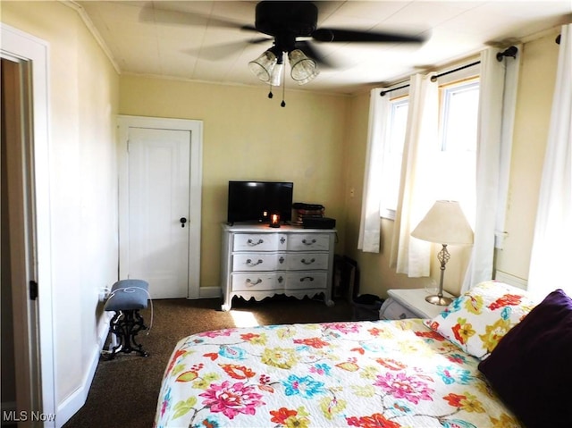 carpeted bedroom with ceiling fan and ornamental molding