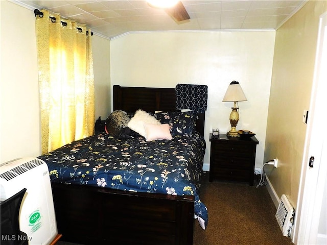 carpeted bedroom featuring heating unit, ceiling fan, and crown molding