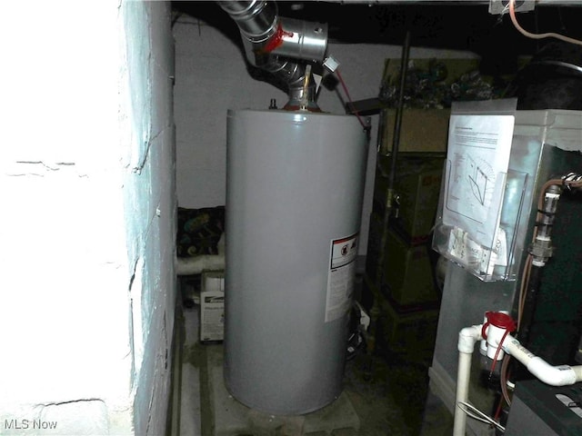 utility room featuring heating unit and gas water heater