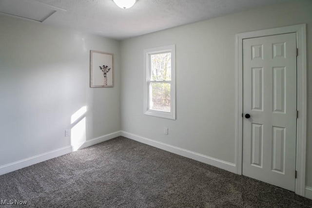 carpeted empty room featuring a textured ceiling