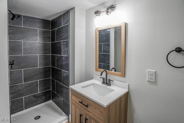 bathroom featuring a tile shower and vanity