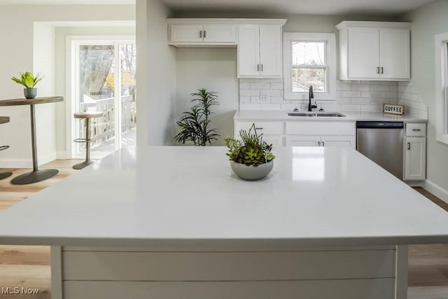 kitchen with dishwasher, a healthy amount of sunlight, white cabinetry, and sink