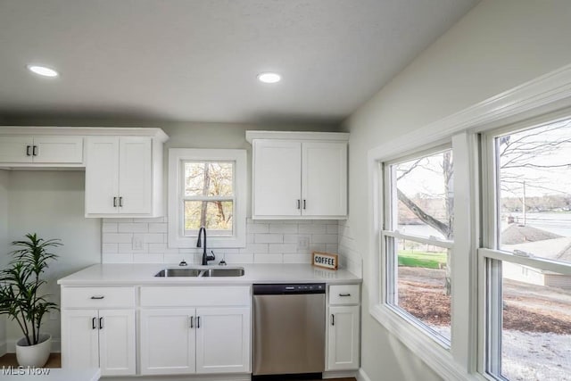 kitchen with dishwasher, white cabinets, and sink