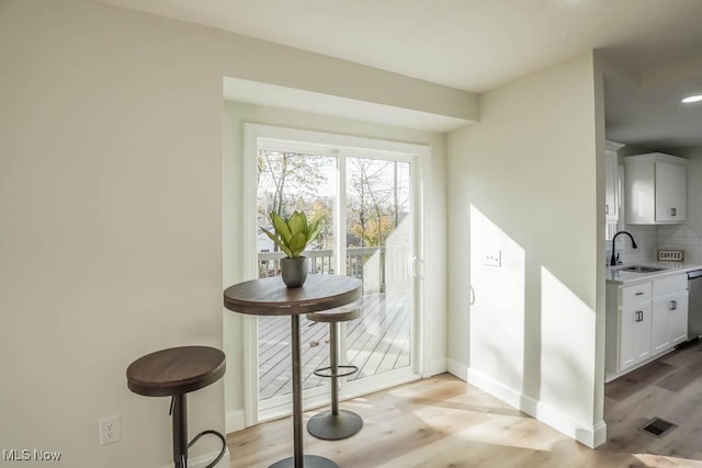 doorway with sink and light hardwood / wood-style flooring