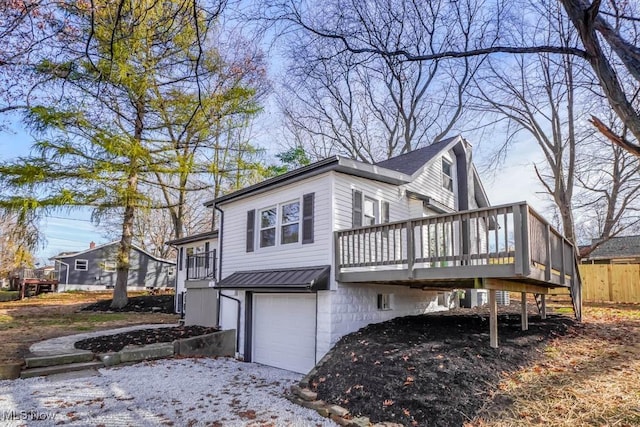 view of property exterior with a garage and a wooden deck