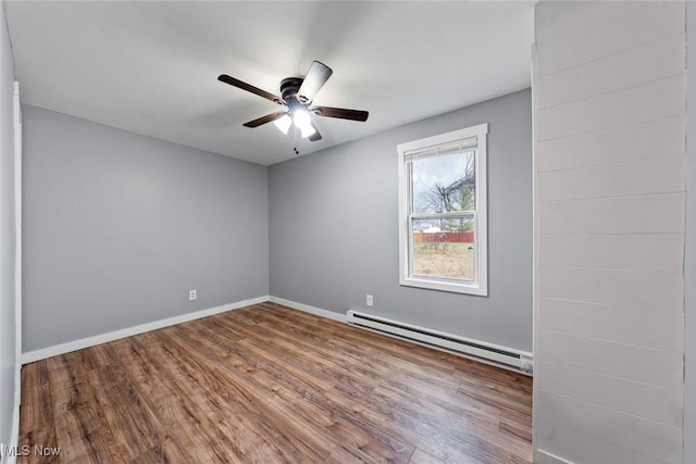 unfurnished room with ceiling fan, wood-type flooring, and a baseboard heating unit