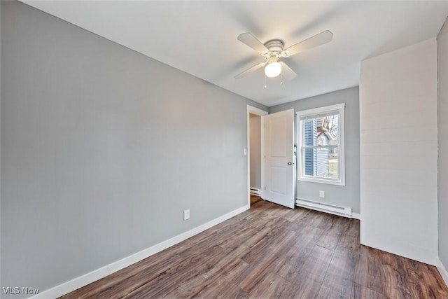 unfurnished bedroom with dark hardwood / wood-style flooring, baseboard heating, and ceiling fan