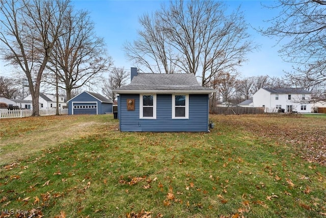 exterior space featuring a lawn, an outdoor structure, and a garage