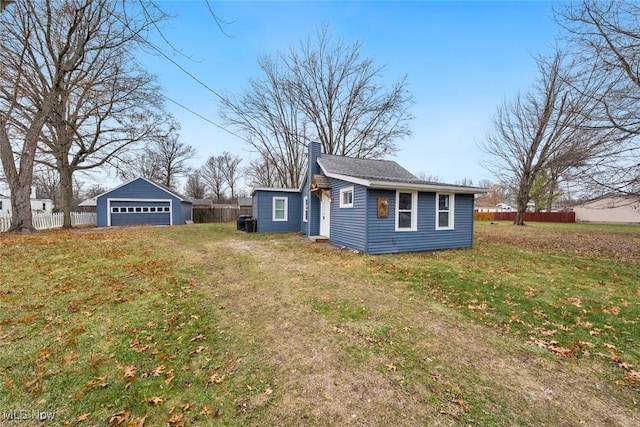 view of side of property featuring a lawn, an outbuilding, and a garage