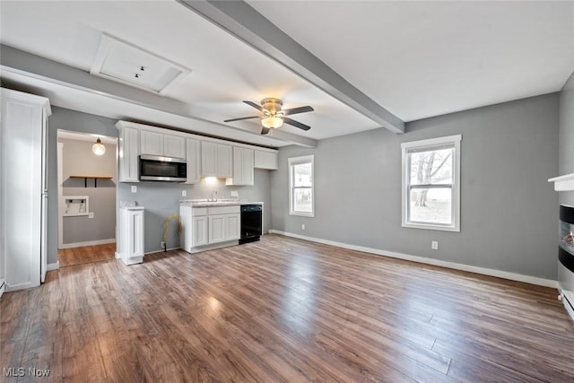 kitchen with hardwood / wood-style floors, sink, ceiling fan, beamed ceiling, and white cabinetry