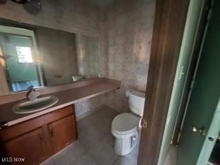 bathroom featuring toilet, vanity, and tile patterned floors