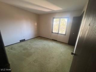 unfurnished room featuring light colored carpet