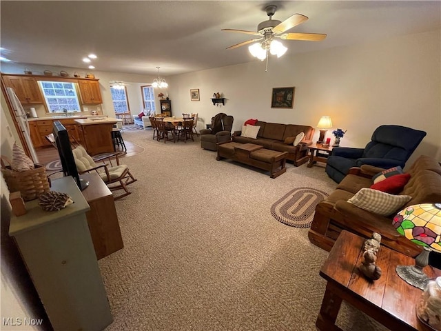 living room featuring light carpet and ceiling fan with notable chandelier