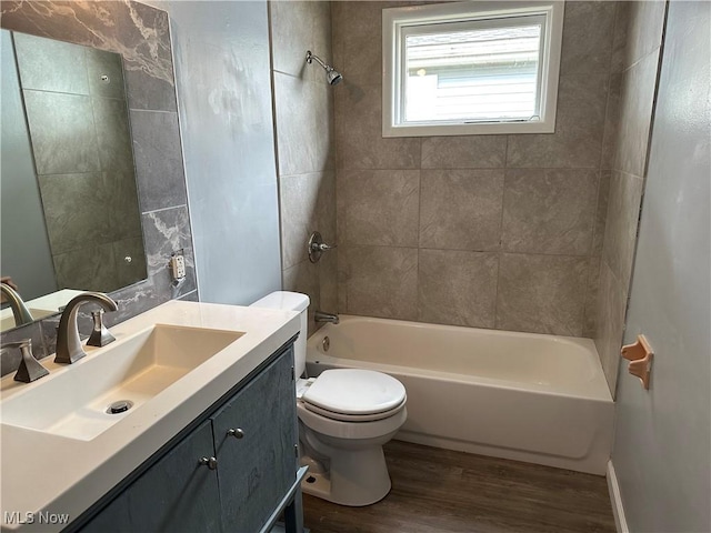 full bathroom featuring toilet, vanity, wood-type flooring, and tiled shower / bath