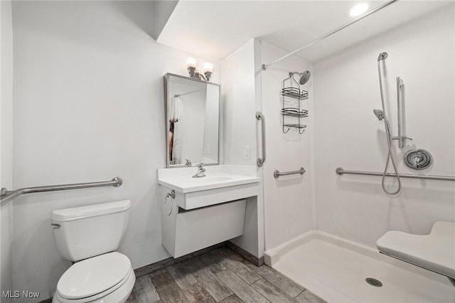 bathroom with a shower, toilet, vanity, and hardwood / wood-style flooring