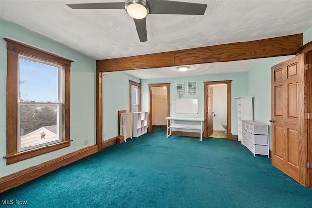 unfurnished room featuring ceiling fan, dark carpet, and a textured ceiling