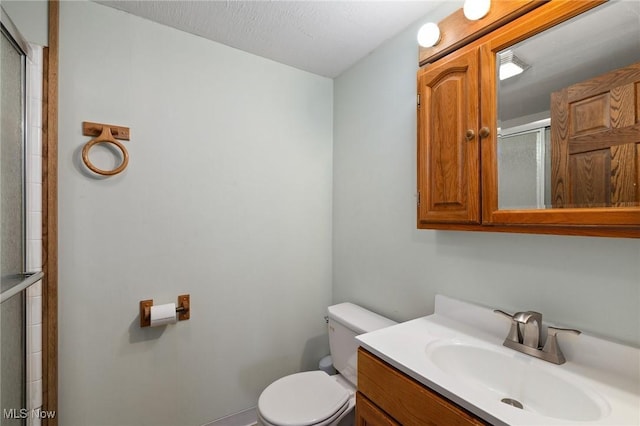 bathroom with vanity, an enclosed shower, and toilet