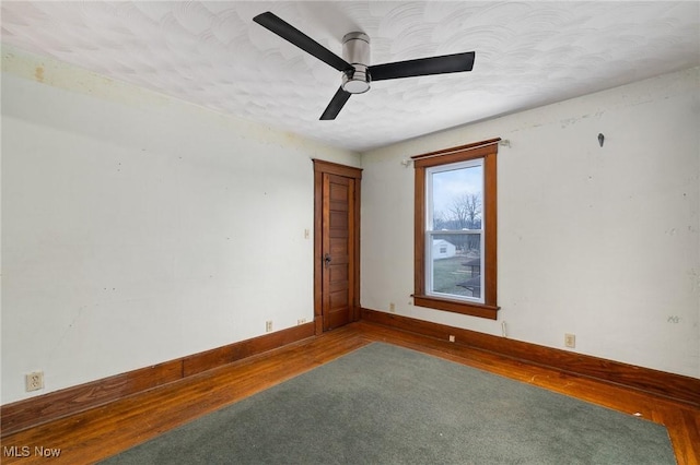 empty room with hardwood / wood-style flooring and ceiling fan