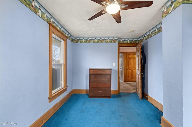 carpeted spare room with ceiling fan