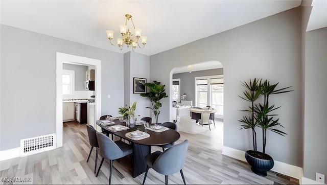 dining area featuring a notable chandelier and light wood-type flooring