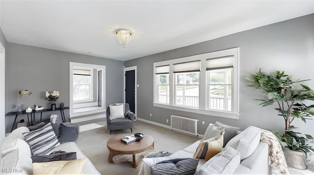 living room with carpet floors, an inviting chandelier, and radiator