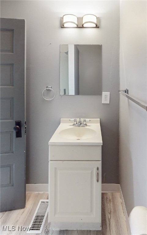 bathroom with hardwood / wood-style floors and vanity