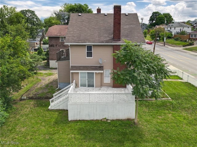 back of house with a yard and a balcony