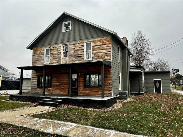 exterior space with a porch, central AC unit, and a front lawn