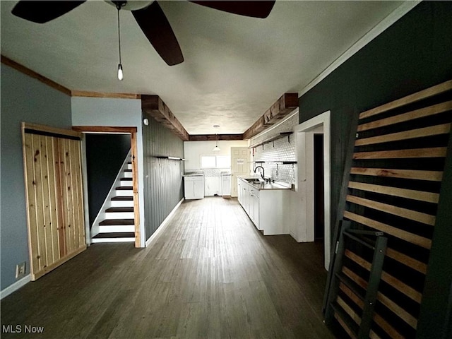 corridor featuring dark hardwood / wood-style floors, ornamental molding, and sink