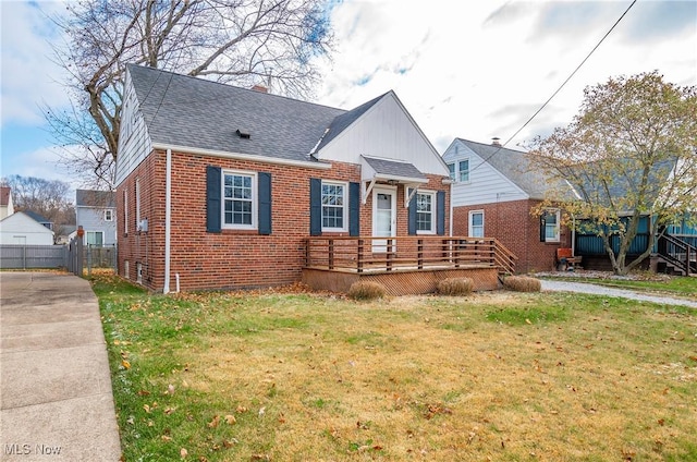 view of front of property with a deck and a front lawn