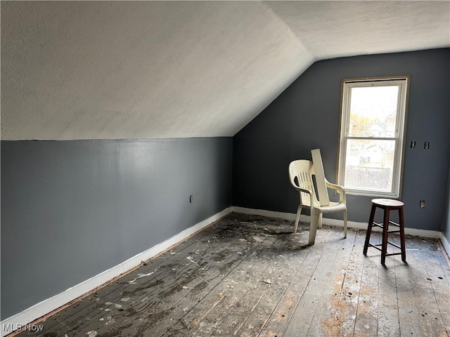 bonus room with wood-type flooring and vaulted ceiling